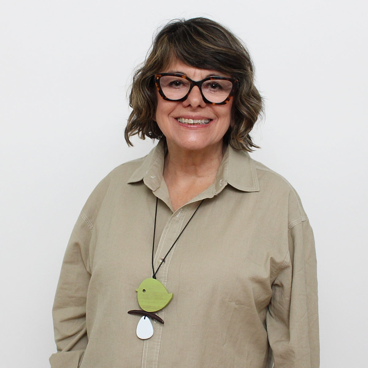 woman wearing green wood bird necklace